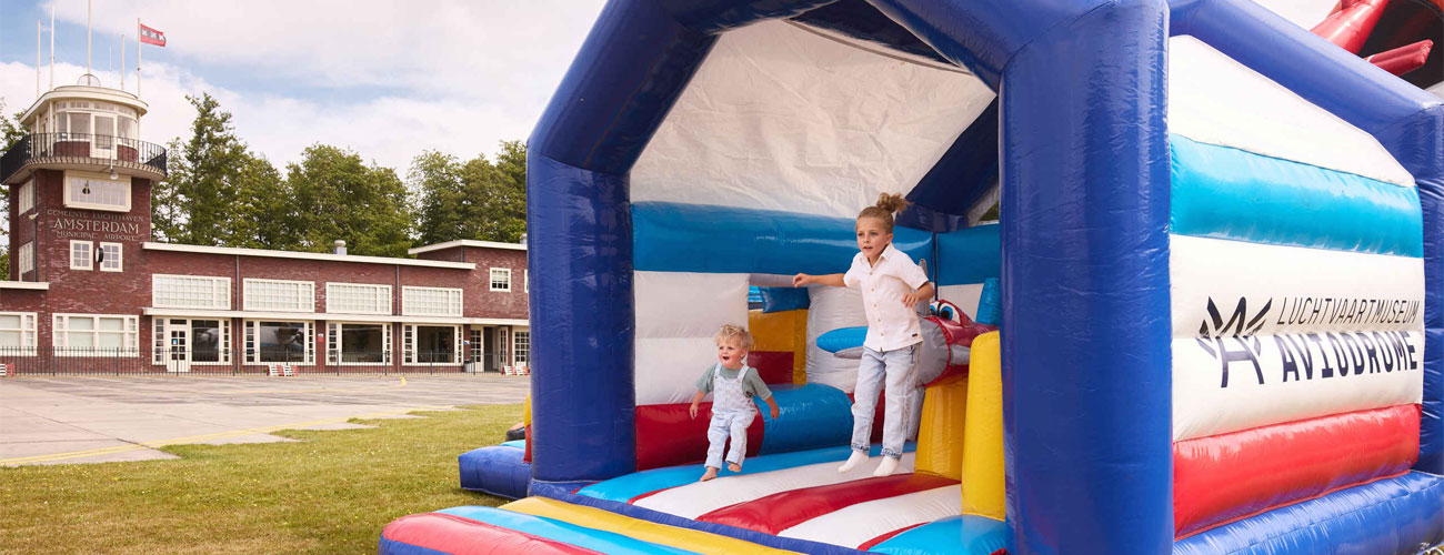 Twee spelende kinderen op een springkussen bij Aviodrome