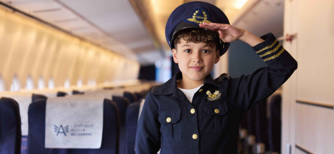 Een jongentje in outfit tijdens de Cabin Crew opleiding bij Aviodrome