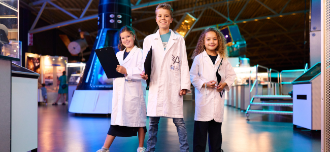 Drie kinderen met labjas bij Space College bij Aviodrome